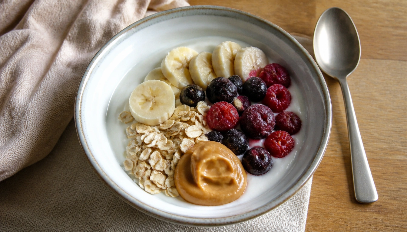 Simple budget-friendly yogurt bowl with plain yogurt, frozen fruit, oats, peanut butter, and seeds